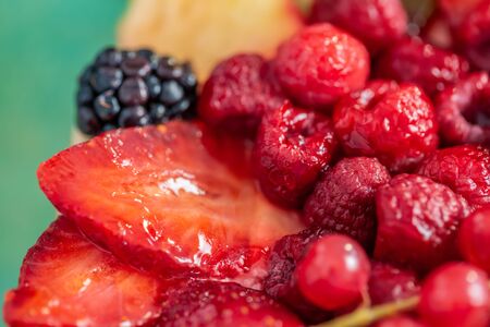Fruits and berries in sweet gelatin on the cake. Background of strawberries, kiwi, currants, raspberry, pineapple, blackberry. Delicious dessert. Soft focus. Closeup. Top view.の写真素材