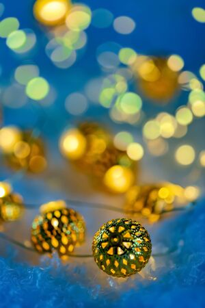 Garland of metallic luminous balls on the snow. Happy New Year and Merry Christmas. Beautiful  blurred background. Greeting card. Shallow depth of field. Toned image. Copy spaceの写真素材