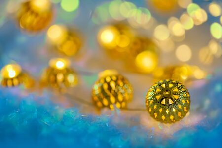 Garland of metallic luminous balls on the snow. Happy New Year and Merry Christmas. Beautiful  blurred background. Greeting card. Shallow depth of field. Toned image. Copy spaceの写真素材