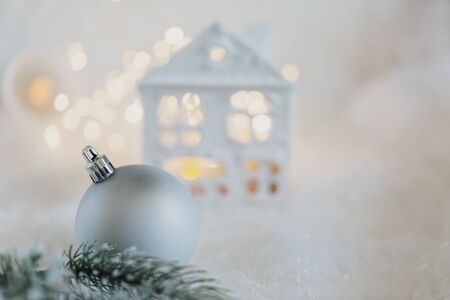 Happy New Year and Merry Christmas. Shallow depth of field house is covered with snow, gray ball and green branches of a pine on the snow. Beautiful background  holiday. Toned image. Copy spaceの写真素材