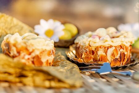Easter cake on a wooden table and bronze paper. Nuts and oval sweet sweets in the form of eggs....