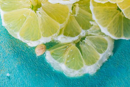 Top view of yellow lemon slices. Transparent juicy slices of lemon blue surface. Healthy vegetarian...