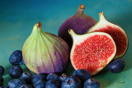 Figs and blueberries on a green old table.の写真素材