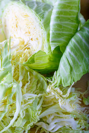 Top view of sliced fresh raw white cabbage with green leaves. Vegetarian healthy tasty food. Shallow depth of field. Soft focus.の写真素材