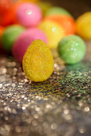 Blurred background with Easter eggs and bokeh on a shiny dark surface. Close-up.The artistic intend and the filters. Film style.の写真素材