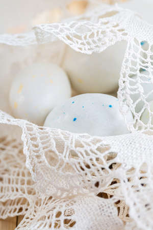 Sweet white eggs with spots in lace. Blurred background. Greeting cards for Easter.の写真素材