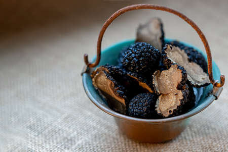 Truffles of Saint John in a small copper bucket. Mushrooms.Black raw champignons. Top view. Shallow depth of field.の写真素材