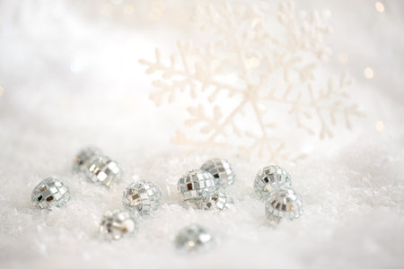 Christmas snowflake and small mirror balls on a white snow. Blurred background with beautiful bokeh. Shallow depth of fieldの写真素材