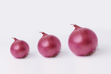 The  red onions on a white background. Onion vegetable bulbs on white background cutoutの写真素材