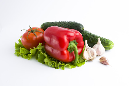 Red peppers and yellow peppers with tomatoes on a white background. Fresh vegetables on a white background. Composition from vegetables. Red and yellow peppers on white background with garlic. Tomato with peppers and cucumber on a white background.の写真素材