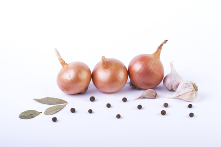 Onions on a white background. Three onions on a white background. Sliced ??onions on a white background. A composition of onions on a white background. Fresh vegetables on a white background.の写真素材