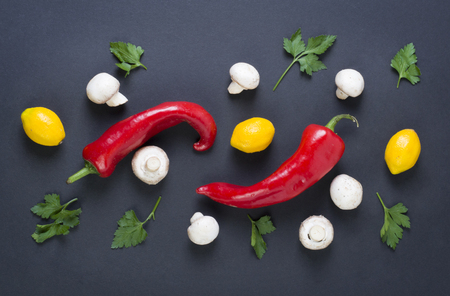Red pepper with mushrooms on a black background. Dietary food. Vegetables on a black background. Bitter pepper with mushrooms on the table.の写真素材