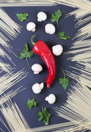 Red pepper with mushrooms on a black background. Composition of pasta with vegetables.の写真素材