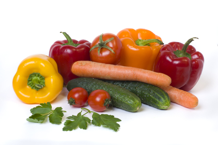 Red yellow and orange peppers with tomatoes on a white background.Cucumbers with colorful peppers in composition on a white background.の写真素材