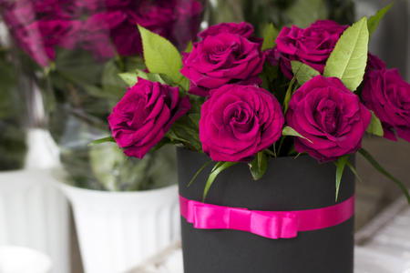 Beautiful bouquet of roses in a gift box. Bouquet of burgundy roses. Bordeaux roses close-upの写真素材