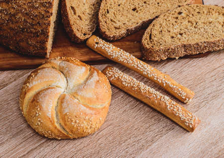 Ð¡risp bread with buns. French baguettes. Fresh crispbread. Bread background. Different breed on wooden background.の写真素材