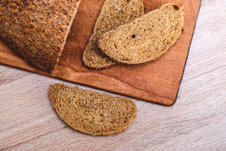 Crisp bread on a wooden board. Gray bran bread sliced on a wooden board.