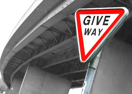 Road sign Give Way  British road sign Give Way opposite the motorway bridge by rainy dayの写真素材