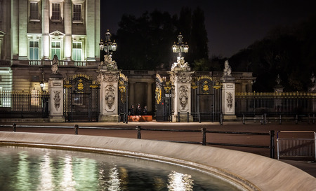 London, England - November 14, 2012   Illuminated gates of Buckingham Palace guarded by police at night  Buckingham Palace is the official London residence of the British monarch のeditorial素材