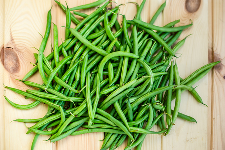 yellow and green beans on a wooden background