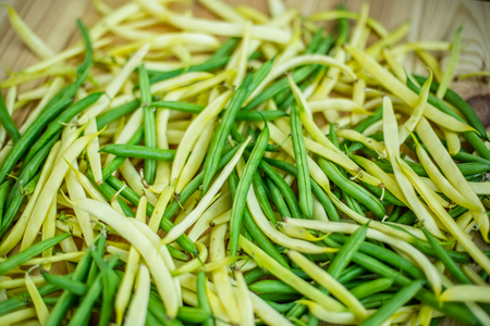 yellow and green beans on a wooden background