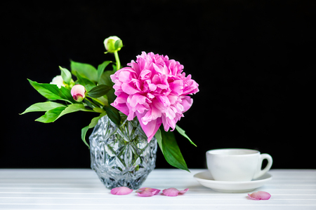 A cup of tea and peonies in a vaseの写真素材