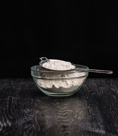 A bowl of wheat flour and a scoop for home baking.の写真素材