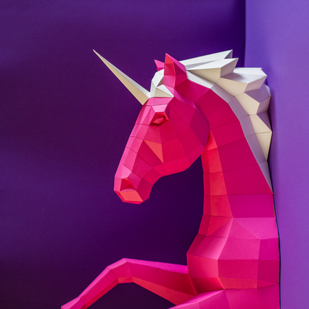 Head of a unicorn of paper on a pink and blue background.の写真素材