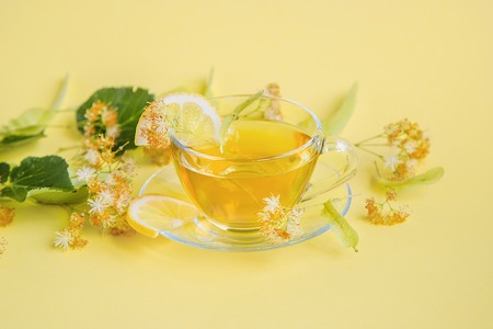 Linden inflorescences, herbal tea, view from high angle, space for a text. On a yellow background.の写真素材