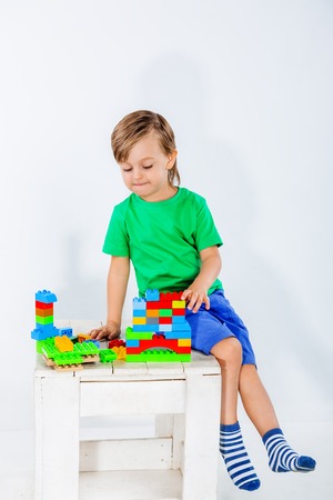 Little boy playing with lots of colorful plastic blocks constructor indoor.の写真素材