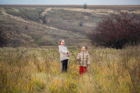 Children run into the field. Children play in the field at the golden hour. Bright autumn colors.の写真素材