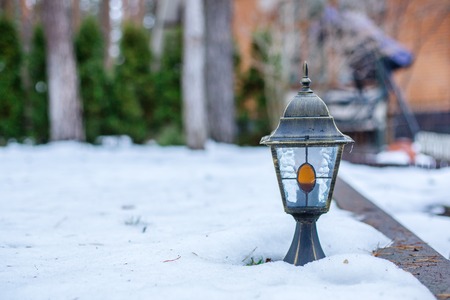 Garden lantern in the winter garden in the middle of the snow. Snowdrifts of snow in the garden.の写真素材