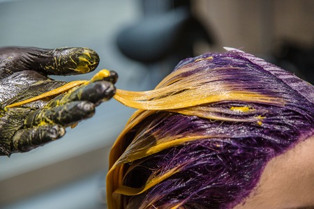 Professional hair coloring for women in the salon, bright and trendy style. Closeup strands of hair.