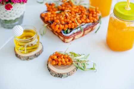Warm sweet organic tea with sea buckthorn berries, thyme and honey. White background, natural...