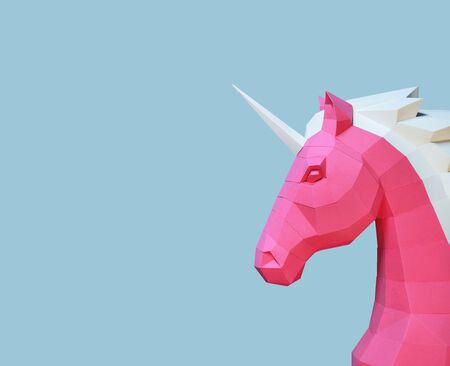 Paper unicorn head on a blue trend background. Geometry, bright and pastel colors. Handmade Decor.