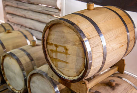Wine production. Wooden wine barrels are found at the winery. They are ready to pour or are already...
