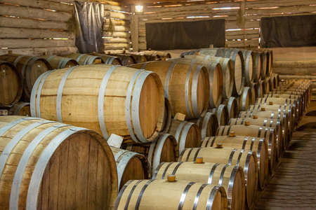 Wine production. Wooden wine barrels are found at the winery. They are ready to pour or are already filled.の写真素材