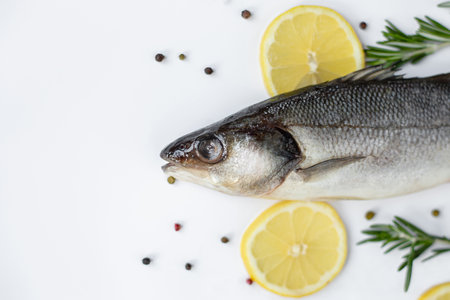 Fresh fish with spices and herbs on table in kitchen. Fresh sea bass. Top view with copy space.の写真素材