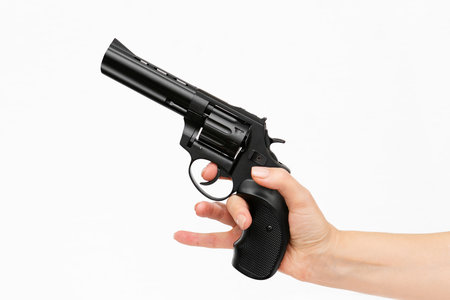 Hand holding gun isolated on white background. After a shot, still ready to use.