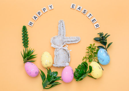 Handmade Easter decor, stylish Easter eggs, textile rabbit willow branches and flowers on light background. Easter wreath shapeの写真素材
