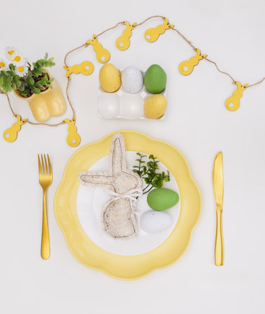 Happy Easter. Easter celebration concept. Top view vertical empty white, yellow plate, decorative...