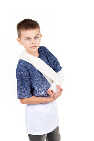 Close up portrait boy, hand bandage isolated on white background concept, child hand injury and bandage dressing. Child with broken hand or hand dislocation isolated on white background.の写真素材