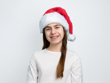 Cheerful little girl in Santa hat showing joy, delight, surprise, approval. Happy emotions, joy of Merry Christmas concept.の写真素材