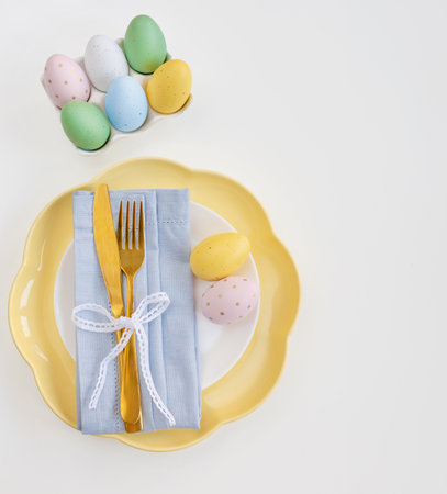 Happy Easter. Easter celebration concept. Top view vertical empty white and yellow plate, Easter eggs, on isolated white background. Copy space, place for text, banner.の写真素材