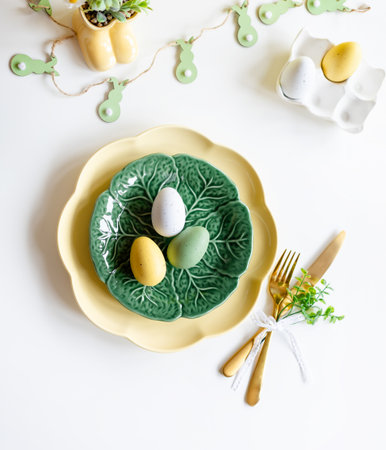 Happy Easter. Easter celebration concept. Top view vertical empty green and yellow plate, Easter eggs, on isolated white background. Copy space, place for text, banner.の写真素材