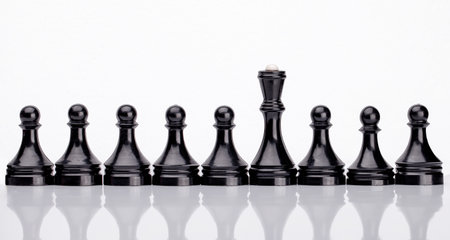 Black Chess Pieces Standing in Row. Chess pieces on chess board with selective focus. Business and motivation concept. Copy spaceの写真素材