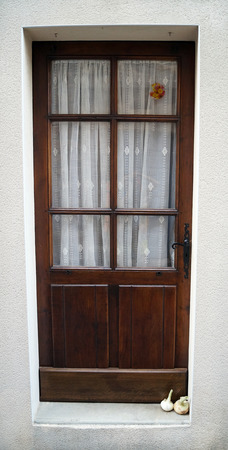 brown door with garlic on the doorstepの写真素材