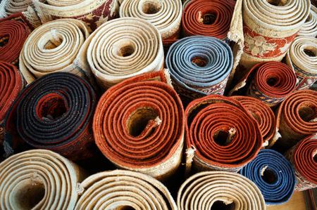 rolled into rolls colored carpets on the floorの写真素材