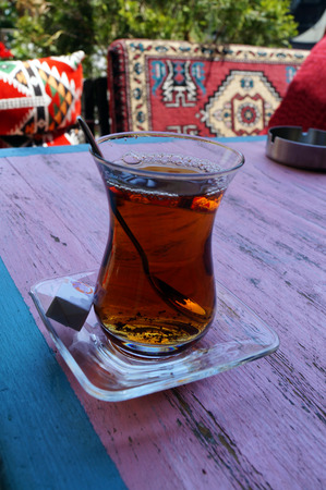 Red Turkish tea with sugar against a background of bright pillowsの写真素材