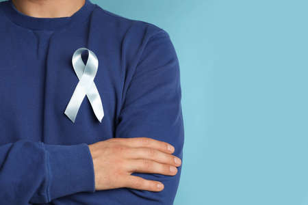 Closeup view of man with ribbon on light blue background, space for text. Urology cancer awarenessの写真素材